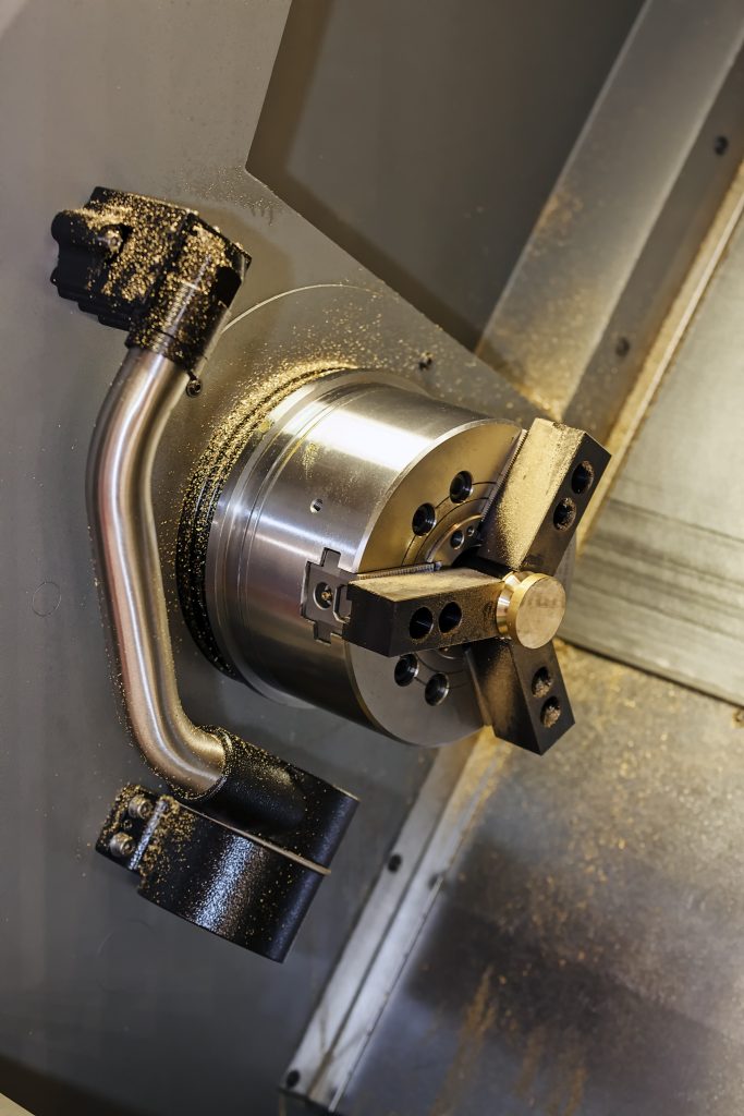 Professioneel CNC draaien van een cilindrisch metalen onderdeel op een industriële draaibank.