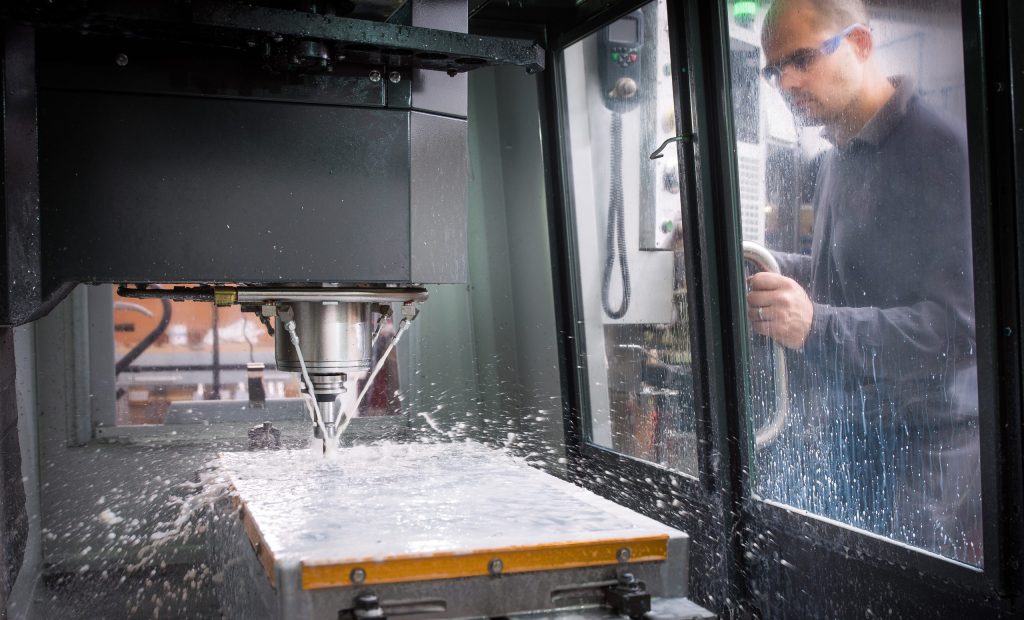 Operator bedient een CNC-machine in een fabriek, onderdeel van het geautomatiseerde proces voor robotlassen